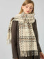 Close-up of a woman wearing a cream, brown, and grey plaid scarf