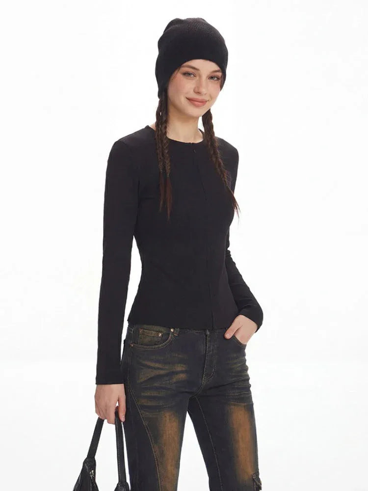 Model smiling and wearing a black ribbed knit top and distressed flared jeans with fur trim cuffs.