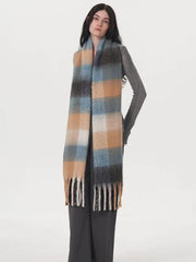 Side view of a model wearing a grey sweater and plaid scarf