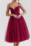 Woman wearing a burgundy tulle tea-length dress with a sweetheart neckline and ruched bodice.