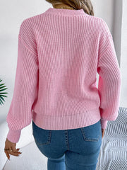 Back view of a woman wearing a pink knit sweater.