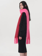 Side view of a woman wearing a black sweater and a two-toned pink and red scarf.