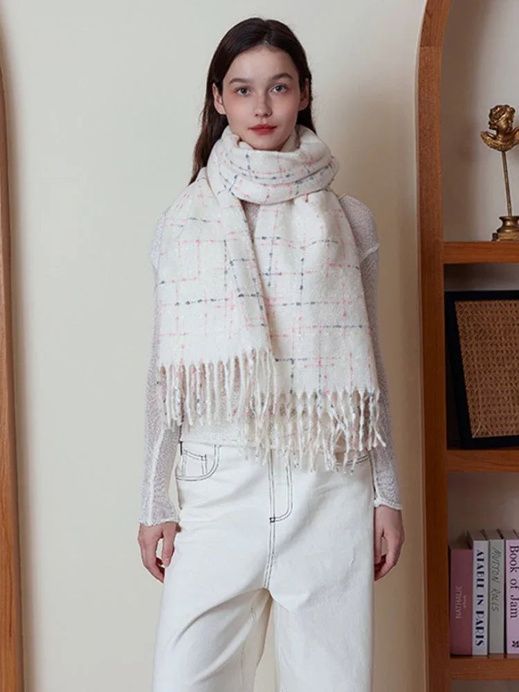 Woman in a white plaid scarf standing in front of a bookshelf