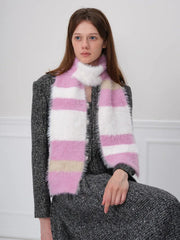 Close-up of a woman wearing a pink, white, and beige striped fuzzy scarf.