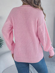 back view of a woman wearing a pink cable knit cardigan