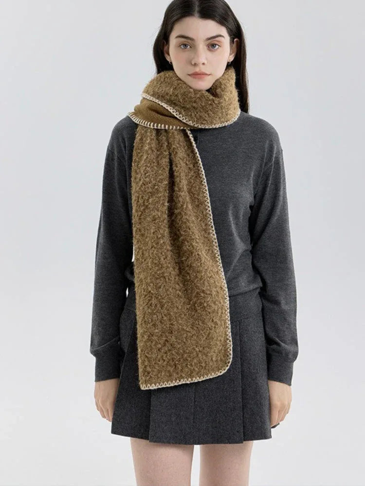 Woman facing forward wearing a brown fuzzy knit scarf and dark grey sweater