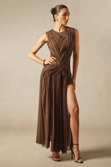 Model in a graceful pose, displaying the fitted bodice and flowing skirt of a brown evening gown.