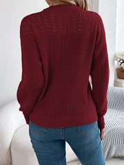 Back view of a woman wearing a maroon knit sweater with open-knit detailing and blue jeans