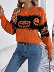 Full-body shot of a woman wearing a festive pumpkin print sweater and denim jeans