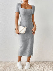 Woman wearing a grey ribbed knit midi dress with short sleeves, a square neckline, and a white handbag.