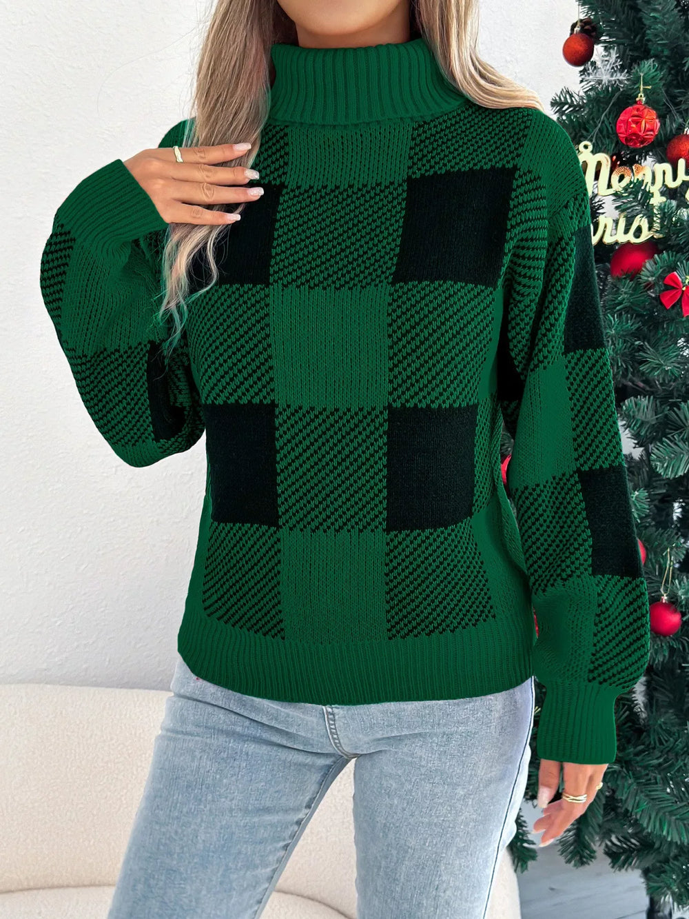 Woman in a green and black buffalo plaid turtleneck sweater posing with hand on hip