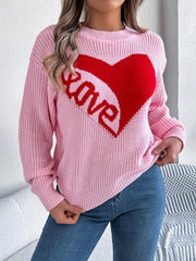 Front view of a woman wearing a pink knit sweater with a red heart graphic and the word "love" on the front.