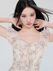 Close-up of the model's face and the neckline of the butterfly print dress, showing ruffled trim and tie detail.