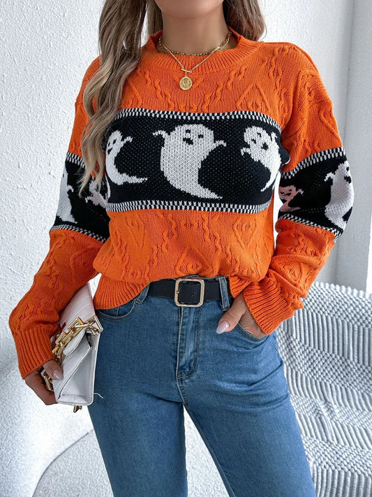 Woman wearing an orange Halloween sweater with a ghost print and cable knit texture, paired with blue jeans and a white clutch.
