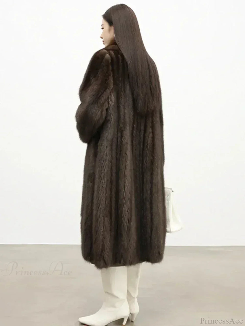 Back view of a woman in a brown mink fur coat and white boots.