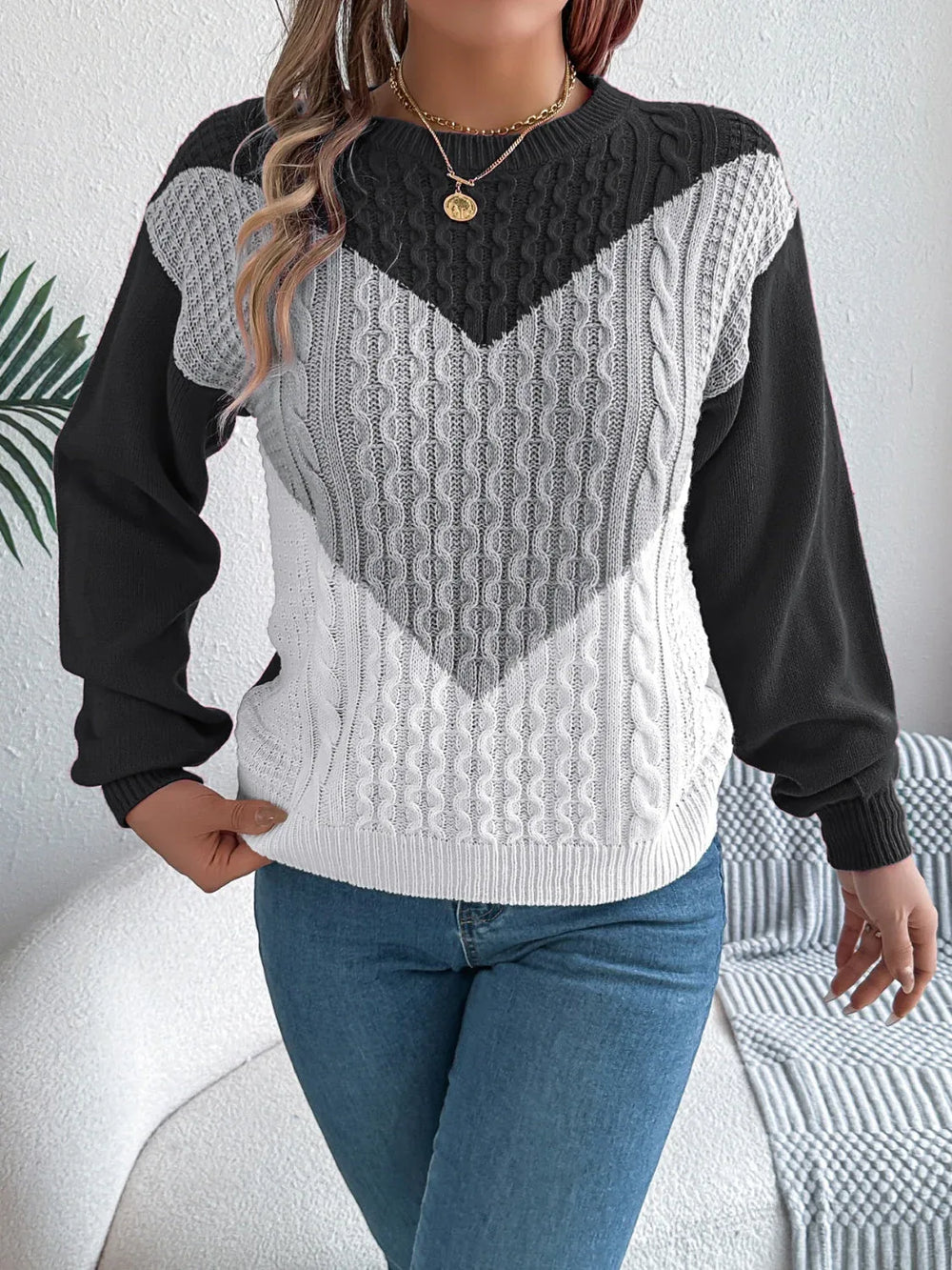 Close-up of a woman wearing a color block chevron cable knit sweater.