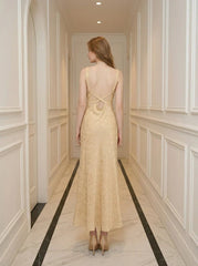 Back view of a woman wearing a sleeveless yellow maxi dress with a floral jacquard pattern and criss-cross back straps.