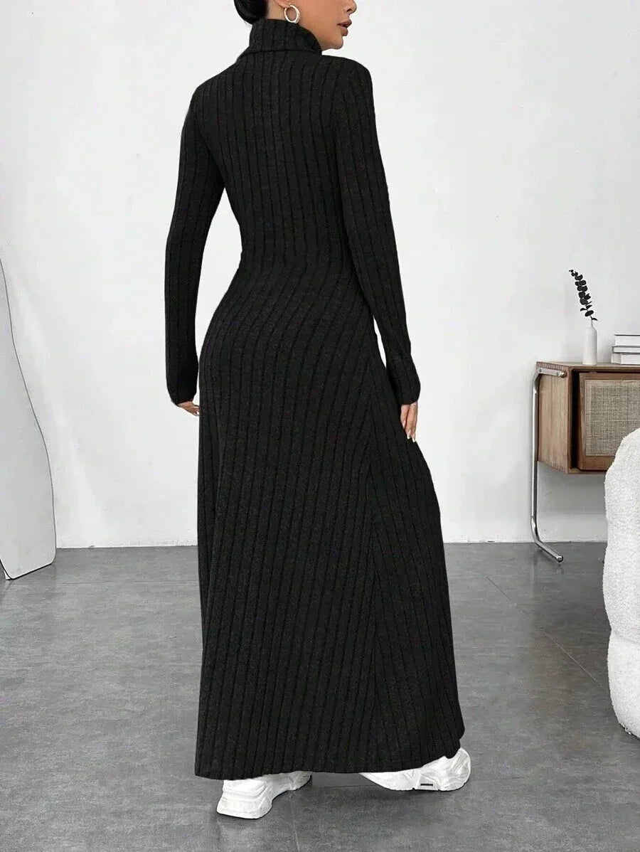 Back view of a woman wearing a black ribbed knit maxi dress with a turtleneck and long sleeves.