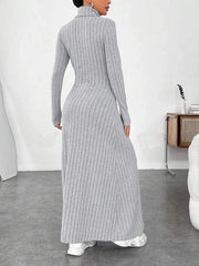 Back view of a woman wearing a grey ribbed knit maxi dress with a turtleneck and long sleeves.