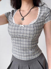 Woman wearing a gray plaid short-sleeved top with a sweetheart neckline and lace trim.