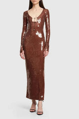 Full-length studio shot of a woman wearing a brown sequined column dress with a plunging neckline and long sleeves.