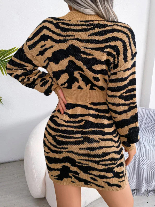 Back view of a woman in a tan and black tiger print knit mini dress with a V-neck and long sleeves.