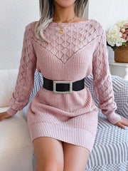 Close-up of a woman wearing a pink knit sweater dress with a detailed open knit pattern
