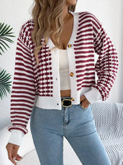 Woman wearing a red and white striped and checkered knit cardigan with a white tank top and blue jeans