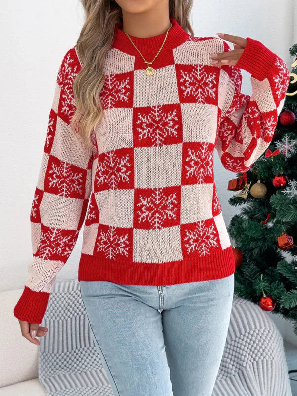 Woman wearing a red and white checkered snowflake print knit sweater with a mock neck and long sleeves.