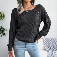 Front view of a woman in a charcoal grey cable knit sweater and blue jeans, showcasing the sweater's texture and button accents.