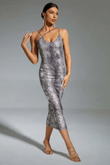 Woman wearing a grey snakeskin print bodycon midi dress with spaghetti straps and clear heels.