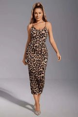 Woman wearing a leopard print bodycon midi dress with spaghetti straps, walking forward.