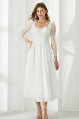 Full-length view of a woman in a white sequined dress with a square neckline and long sleeves.