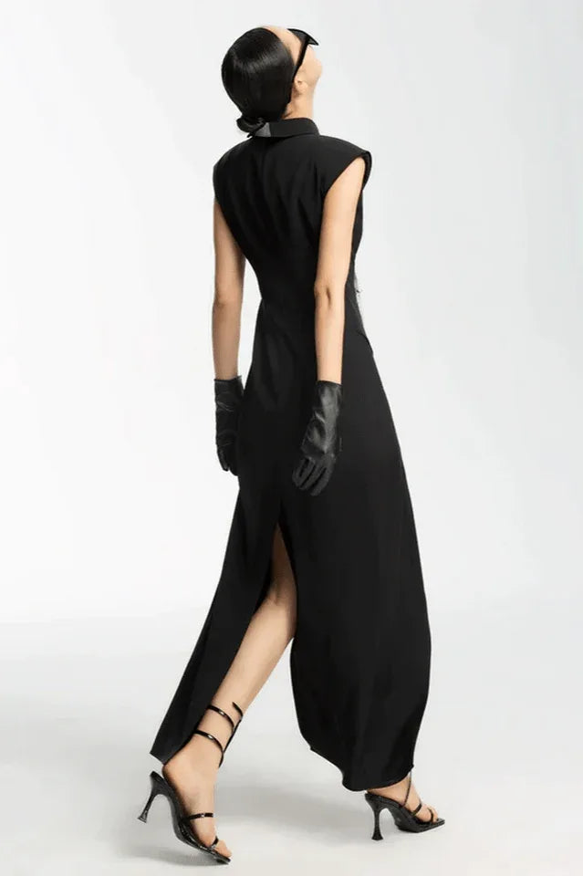 Back view of a model wearing a black sleeveless maxi dress with a high slit and white tie detail