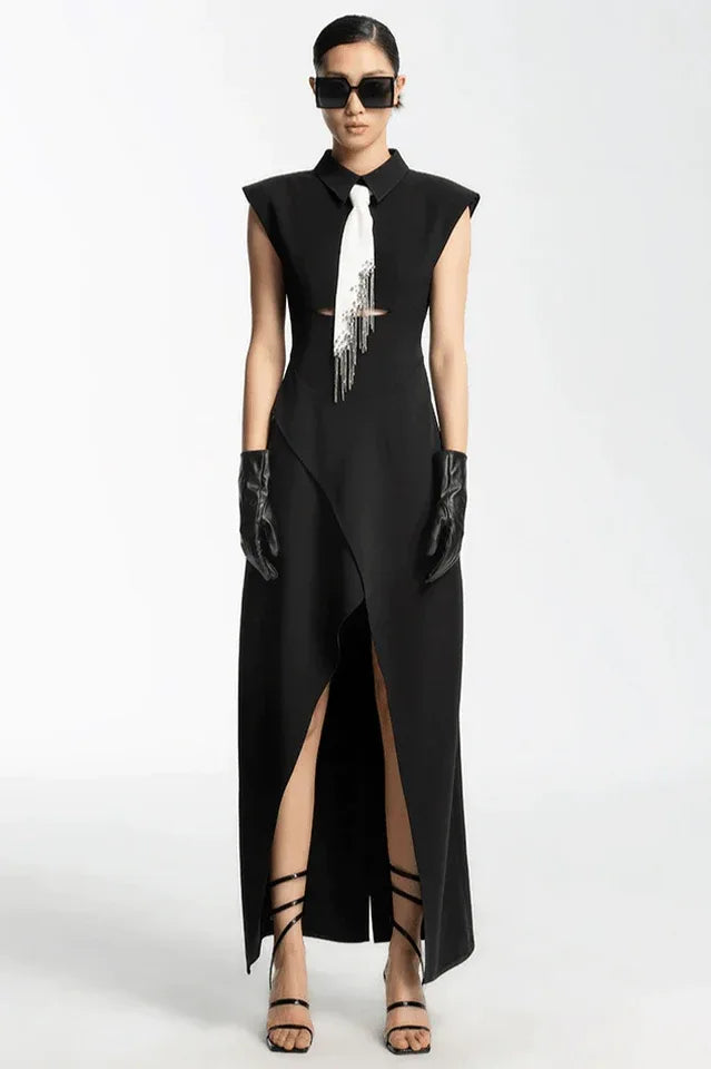 Model wearing a black sleeveless maxi dress with a white tie detail, sunglasses, and black gloves