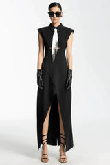 Model wearing a black sleeveless maxi dress with a white tie detail, sunglasses, and black gloves