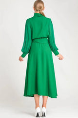 Back view of a woman in a green long-sleeved dress with a midi-length skirt.