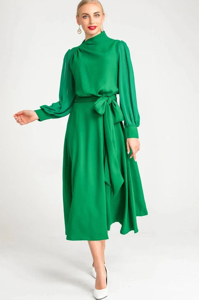 Side profile of a woman showcasing the silhouette of a green A-line dress.