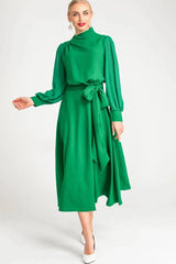Side profile of a woman showcasing the silhouette of a green A-line dress.