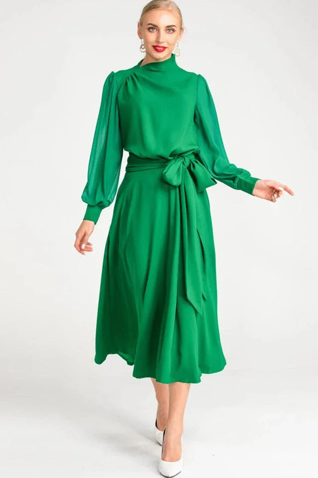 Full body shot of a woman modeling a formal green midi dress.