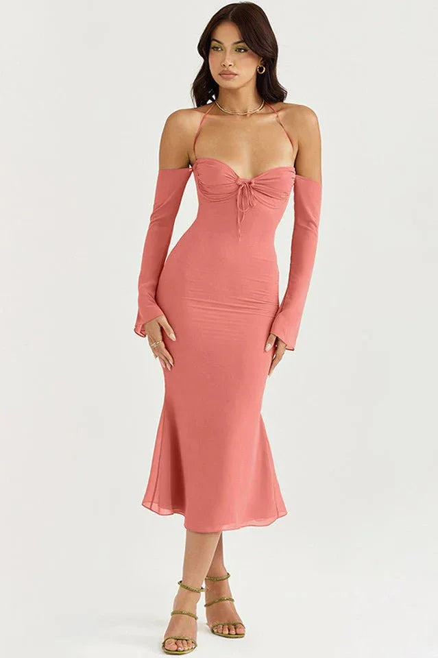 Woman wearing a coral ruched midi dress with detachable sleeves and halter neckline, full body shot