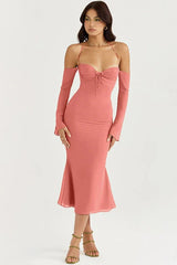 Woman wearing a coral ruched midi dress with detachable sleeves and halter neckline, full body shot