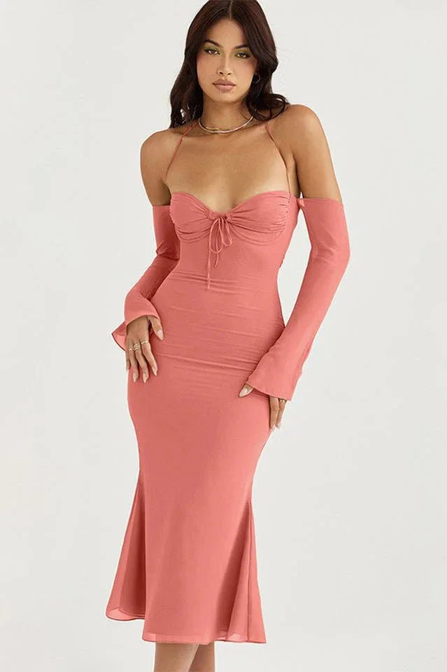 Woman in a coral ruched midi dress with detachable sleeves from the side