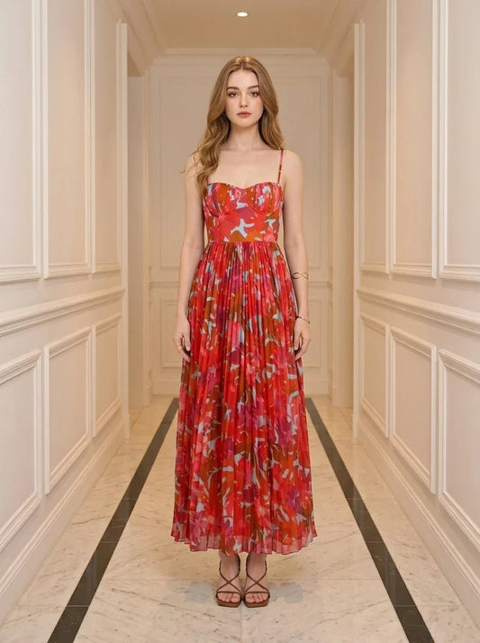 Woman standing in a hallway wearing a red floral print maxi dress with spaghetti straps and a sweetheart neckline.