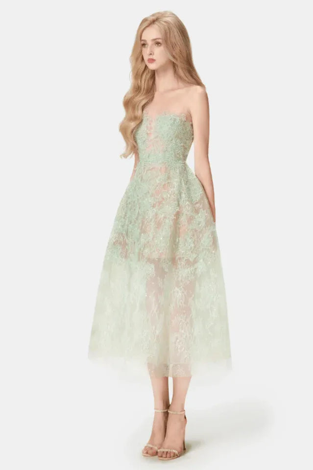 Woman wearing a strapless mint green lace midi dress with a full skirt, side view