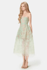 Woman wearing a strapless mint green lace midi dress with a full skirt, side view
