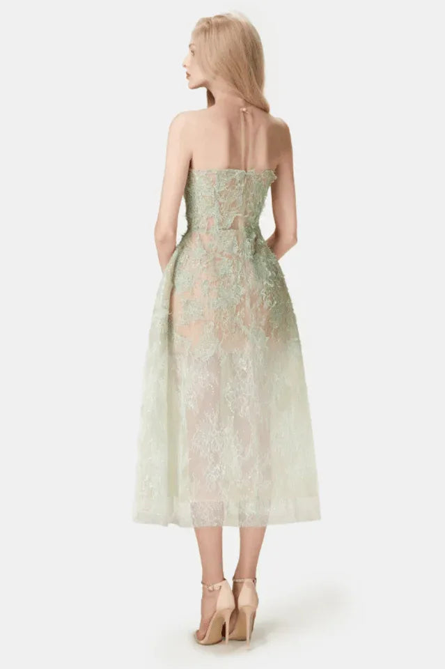 Woman wearing a strapless mint green lace midi dress with a full skirt, back view