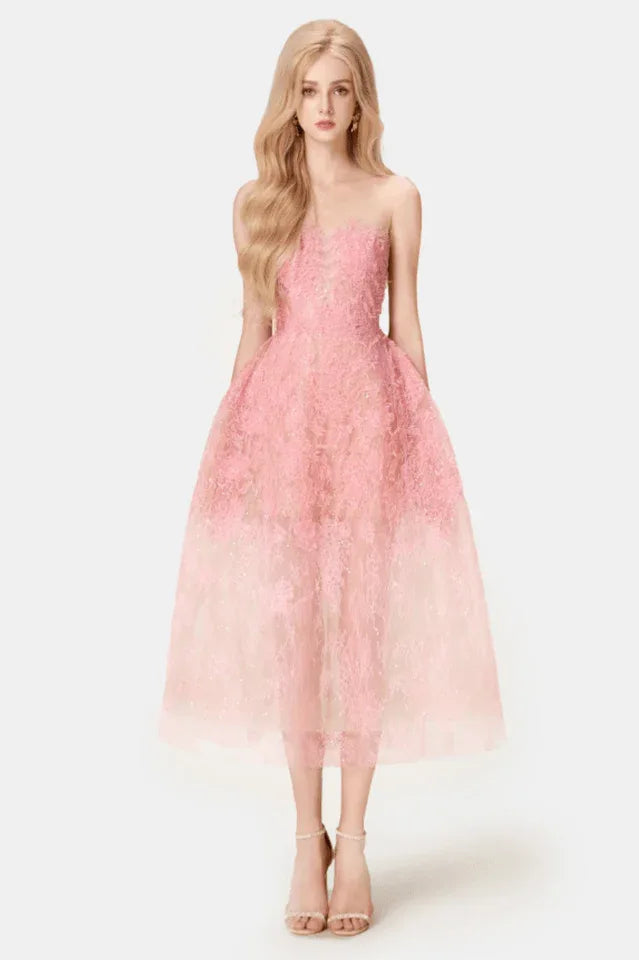 Woman wearing a strapless pink lace midi dress with a full skirt, front view