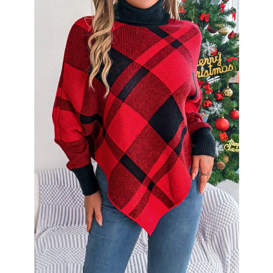 Woman wearing a red and black plaid turtleneck poncho with blue jeans.