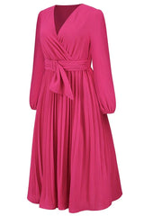 Three-quarter side view of a long-sleeved pink wrap dress with a pleated skirt and a self-tie belt